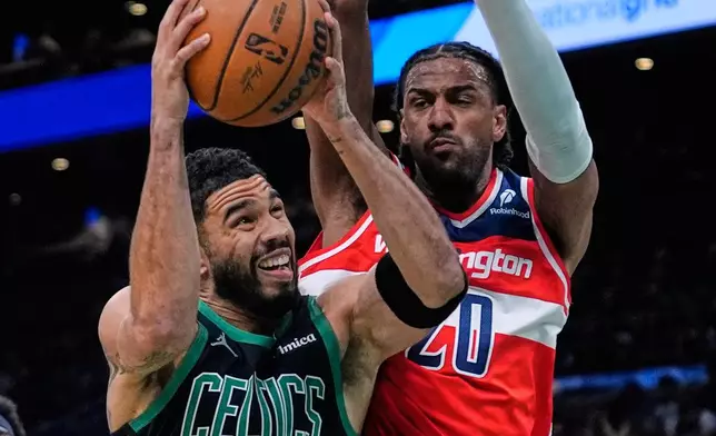 Boston Celtics forward Jayson Tatum (0) drives to the basket against Washington Wizards center Alex Sarr, right, during the first half of an NBA basketball game, Saturday, March 14, 2026, in Boston. (AP Photo/Charles Krupa)