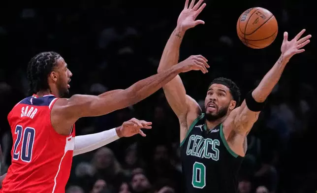 Boston Celtics forward Jayson Tatum (0) reaches up to block a pass by Washington Wizards center Alex Sarr (20) during the first half of an NBA basketball game, Saturday, March 14, 2026, in Boston. (AP Photo/Charles Krupa)