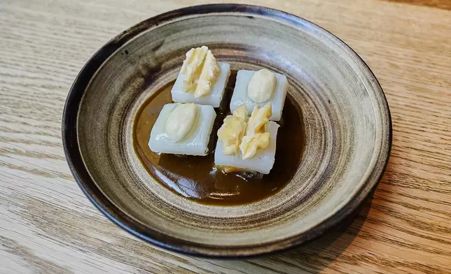A cured squid, white cabbage, hazelnuts and walnuts dish served at restaurant Kadeau in Copenhagen, Denmark, Feb. 12, 2026. (AP Photo/James Brooks)