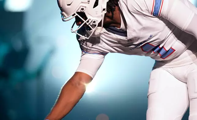 Tennessee Titans quarterback Cam Ward greets fans as he models a new uniform during the NFL football team's event Thursday, March 12, 2026, in Nashville, Tenn. (AP Photo/George Walker IV)