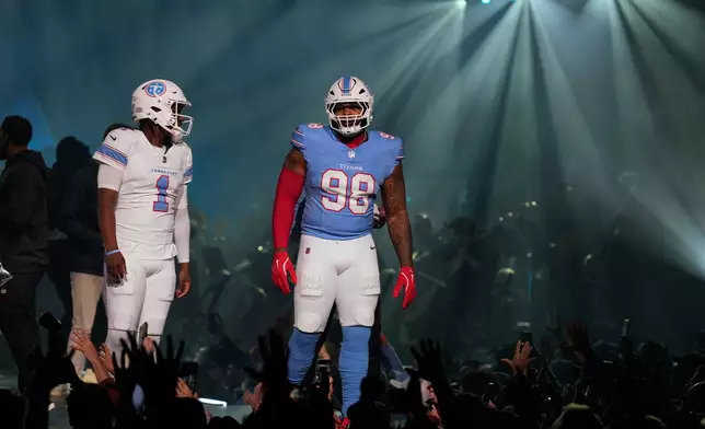 Tennessee Titans quarterback Cam Ward (1) and defensive tackle Jeffery Simmons, right, model new uniforms during the NFL football team's event Thursday, March 12, 2026, in Nashville, Tenn. (AP Photo/George Walker IV)