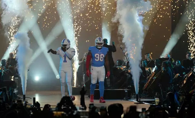 Tennessee Titans quarterback Cam Ward (1) and defensive tackle Jeffery Simmons (98) model new uniforms during the NFL football team's event Thursday, March 12, 2026, in Nashville, Tenn. (AP Photo/George Walker IV)
