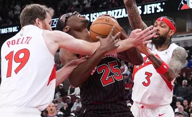 Chicago Bulls center Jalen Smith, center, battles for a ball against Toronto Raptors center Jakob Poeltl, left, and forward Brandon Ingram during the first half of an NBA basketball game in Chicago, Wednesday, March 18, 2026. (AP Photo/Nam Y. Huh)