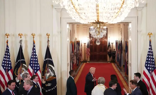 President Donald Trump waves goodbye as he leaves a roundtable discussion on college sports in the East Room of the White House, Friday, March 6, 2026, in Washington. (AP Photo/Julia Demaree Nikhinson)