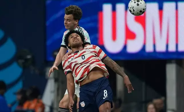 United States' Weston McKennie (8) and Belgium's Thomas Meunier battle for a head ball during the first half of an international friendly soccer match, Saturday, March 28, 2026, in Atlanta. (AP Photo/Mike Stewart)
