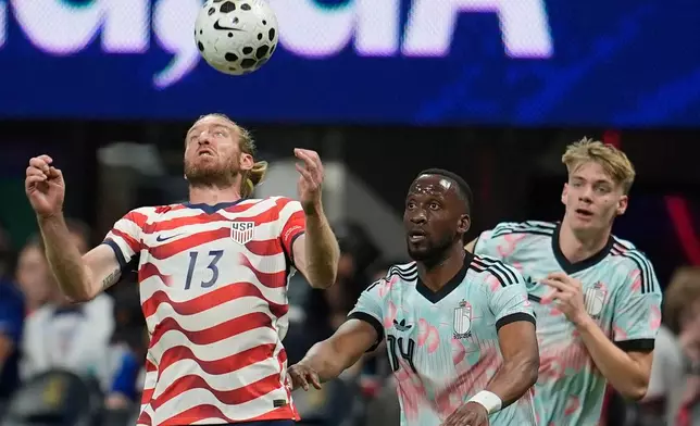 United States' Tim Ream (13) tries the control the ball as Belgium's Dodi Lukebakio (14) looks on during the second half of an international friendly soccer match, Saturday, March 28, 2026, in Atlanta. (AP Photo/Mike Stewart)