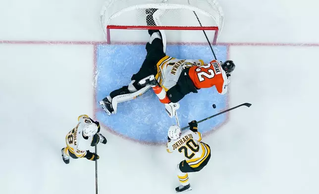Boston Bruins' Jeremy Swayman, center left, makes a save on the shot attempt by Philadelphia Flyers' Christian Dvorak, right, during the second period of an NHL hockey game Saturday, Feb. 28, 2026, in Philadelphia. (AP Photo/Chris Szagola)