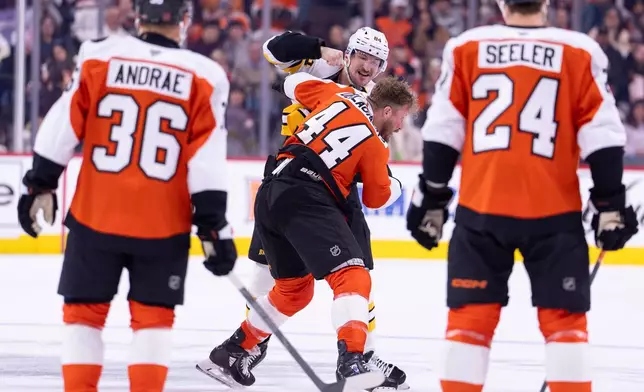 Boston Bruins' Tanner Jeannot, center left, fights with Philadelphia Flyers' Nicolas Deslauriers, center right, as teammates look on during the first period of an NHL hockey game Saturday, Feb. 28, 2026, in Philadelphia. (AP Photo/Chris Szagola)