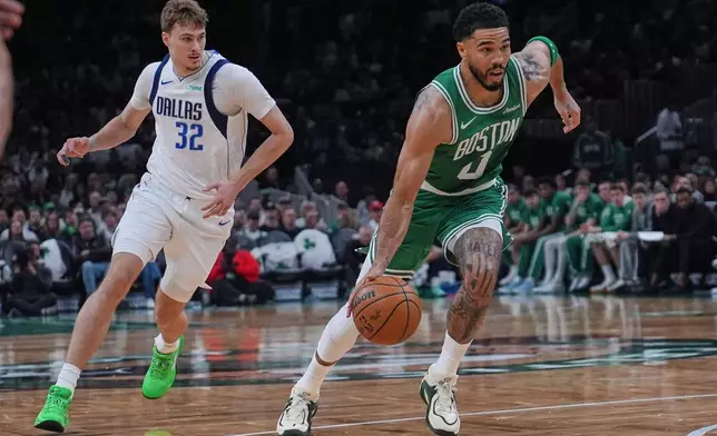 Boston Celtics forward Jayson Tatum (0) drives to the basket against Dallas Mavericks forward Cooper Flagg (32) during the second half of an NBA basketball game, Friday, March 6, 2026, in Boston. (AP Photo/Charles Krupa)