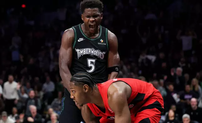 Minnesota Timberwolves guard Anthony Edwards (5) celebrates his dunk in front of Toronto Raptors forward RJ Barrett (9) during the second half of an NBA basketball game Thursday, March 5, 2026, in Minneapolis. (AP Photo/Matt Krohn)