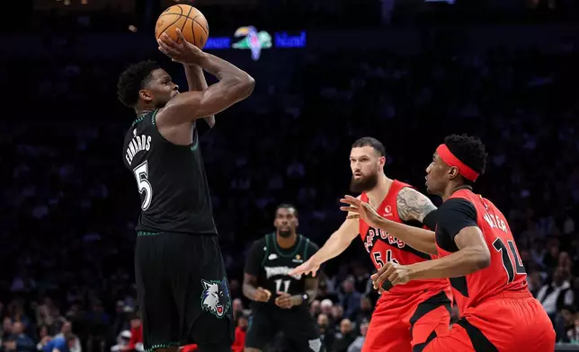 Minnesota Timberwolves guard Anthony Edwards, left, shoots over Toronto Raptors guard Ja'kobe Walter, right, during the second half of an NBA basketball game, Thursday, March 5, 2026, in Minneapolis. (AP Photo/Matt Krohn)