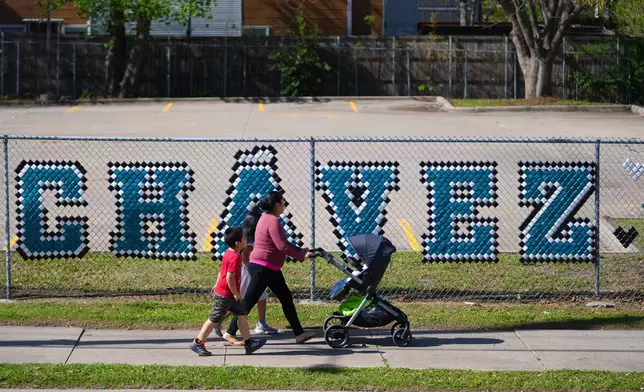 FILE - Pedestrians walk past the parking lot of the Cesar Chavez Learning Center in Dallas, March 19, 2026. (AP Photo/Julio Cortez, File)