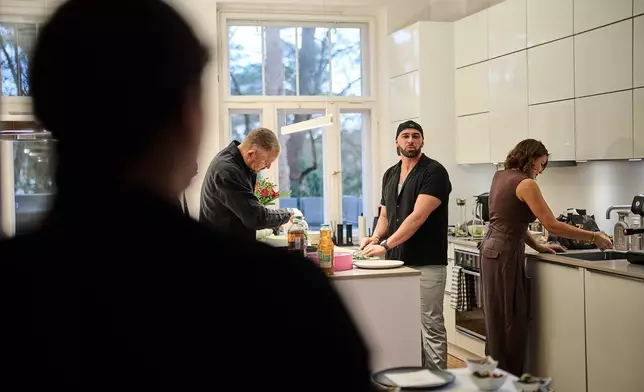 Gay Muslim influencer Ali Darwich, center, hosts an inclusive Iftar, the Ramadan fast-breaking meal, with friends who are Muslim, Christian, queer and straight, in Berlin, Germany, Wednesday, March 11, 2026. (AP Photo/Ebrahim Noroozi)