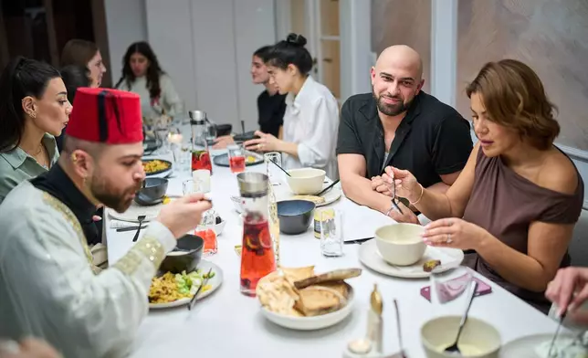 Gay Muslim influencer Ali Darwich, second right, hosts an inclusive Iftar, the Ramadan fast-breaking meal, with friends who are Muslim, Christian, queer and straight, in Berlin, Germany, Wednesday, March 11, 2026. (AP Photo/Ebrahim Noroozi)
