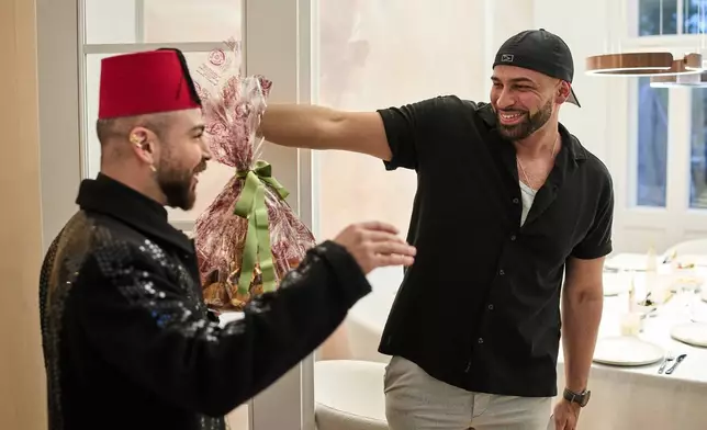 Gay Muslim influencer Ali Darwich, right, welcomes friends for an inclusive Iftar, the Ramadan fast-breaking meal, with friends who are Muslim, Christian, queer and straight, in Berlin, Germany, Wednesday, March 11, 2026. (AP Photo/Ebrahim Noroozi)