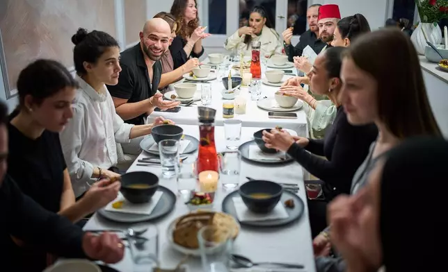 Gay Muslim influencer Ali Darwich, center left, hosts an inclusive Iftar, the Ramadan fast-breaking meal, with friends who are Muslim, Christian, queer and straight, in Berlin, Germany, Wednesday, March 11, 2026. (AP Photo/Ebrahim Noroozi)
