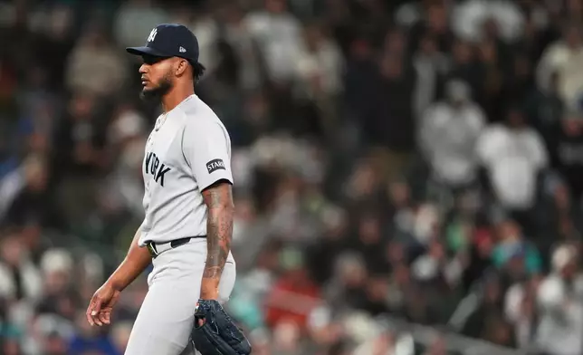 New York Yankees relief pitcher Camilo Doval walks to the dugout after retiring the side against the Seattle Mariners during the seventh inning of a baseball game, Monday, March 30, 2026, in Seattle. (AP Photo/Lindsey Wasson)