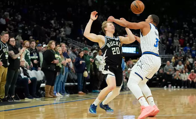 Milwaukee Bucks' AJ Green (20) loses control of the ball against Orlando Magic's Desmond Bane during the first half of an NBA basketball game Sunday, March 8, 2026, in Milwaukee. (AP Photo/Aaron Gash)