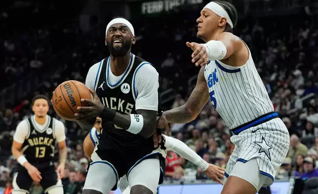 Milwaukee Bucks' Bobby Portis, left, looks to shoot against Orlando Magic's Paolo Banchero during the first half of an NBA basketball game, Sunday, March 8, 2026, in Milwaukee. (AP Photo/Aaron Gash)