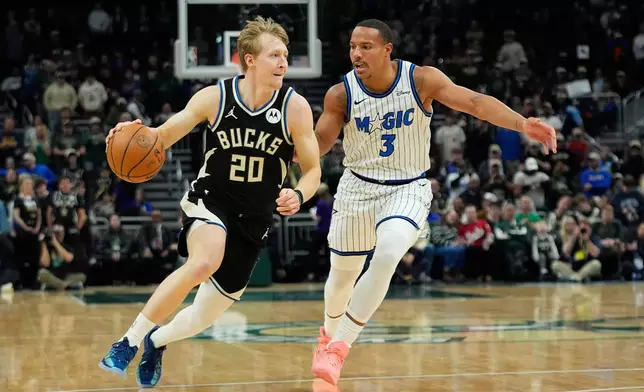 Milwaukee Bucks' AJ Green (20) drives to the basket against Orlando Magic's Desmond Bane during the first half of an NBA basketball game, Sunday, March 8, 2026, in Milwaukee. (AP Photo/Aaron Gash)
