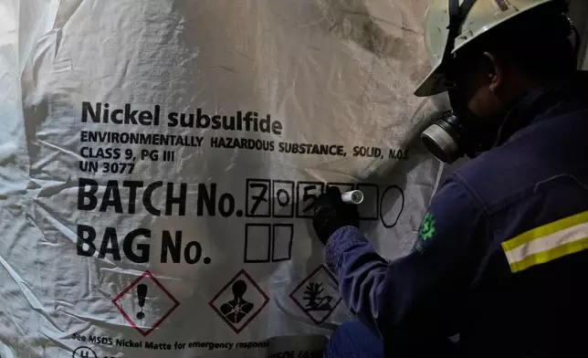 FILE - A worker writes batch numbers on a bag of nickel matte at a processing plant in Sorowako, South Sulawesi, Indonesia, on Sept. 12, 2023. (AP Photo/Dita Alangkara, File)