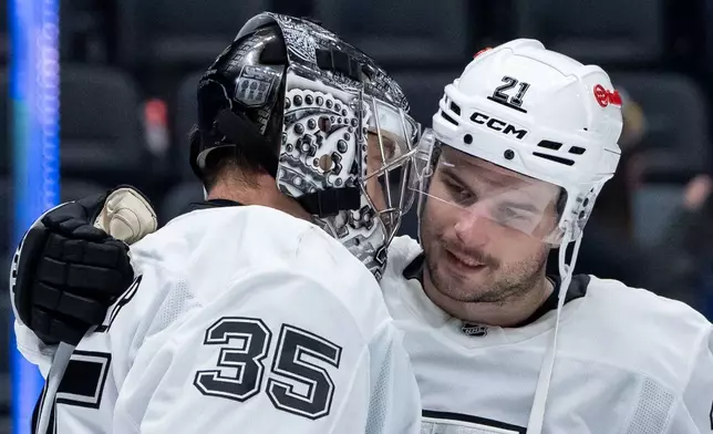 Los Angeles Kings goaltender Darcy Kuemper (35) celebrates with Los Angeles Kings' Scott Laughton (21) after defeating the Vancouver Canucks in an NHL hockey game in Vancouver, British Columbia, Thursday, March 26, 2026. (Ethan Cairns/The Canadian Press via AP)