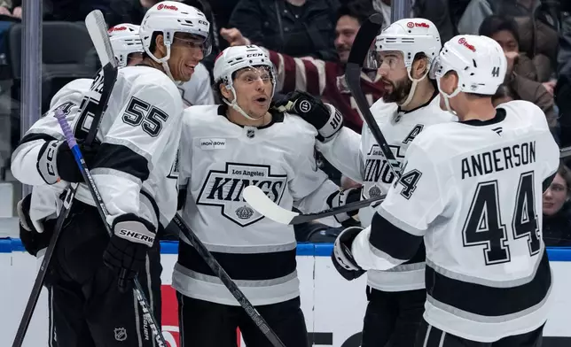 Los Angeles Kings' Trevor Moore, center, celebrates after his goal against the Vancouver Canucks with Quinton Byfield (55), Alex Laferriere,back left, Drew Doughty, second from right, and Mikey Anderson (44) during the second period of an NHL hockey game in Vancouver, British Columbia, Thursday, March 26, 2026. (Ethan Cairns/The Canadian Press via AP)