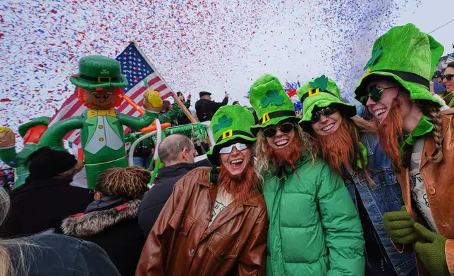 Women wearing leprechaun hats and beards smile as confetti cannons blast during the annual St. Patrick's Day parade through the South Boston neighborhood, Sunday, March 15, 2026, in Boston. (AP Photo/Charles Krupa)