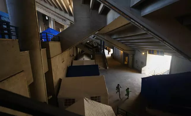 Displaced children run between tents set up inside the Camille Chamoun Sports City Stadium, which has been turned into a shelter for people displaced by Israeli airstrikes in southern Lebanon and Dahiyeh, Beirut's southern suburbs, in Beirut, Lebanon, Tuesday, March 10, 2026. (AP Photo/Hassan Ammar)