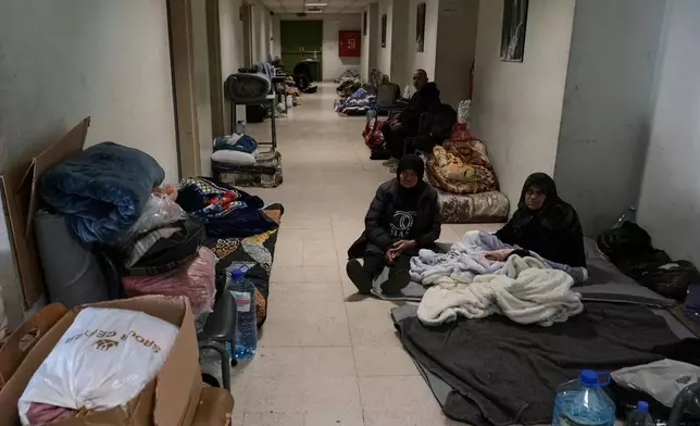 Displaced people fleeing Israeli airstrikes in southern Lebanon and Dahiyeh, Beirut's southern suburbs, settle at the Bir Hassan Technical Institute, which has been turned into a shelter, in Beirut, Lebanon, Wednesday, March 11, 2026. (AP Photo/Bilal Hussein)