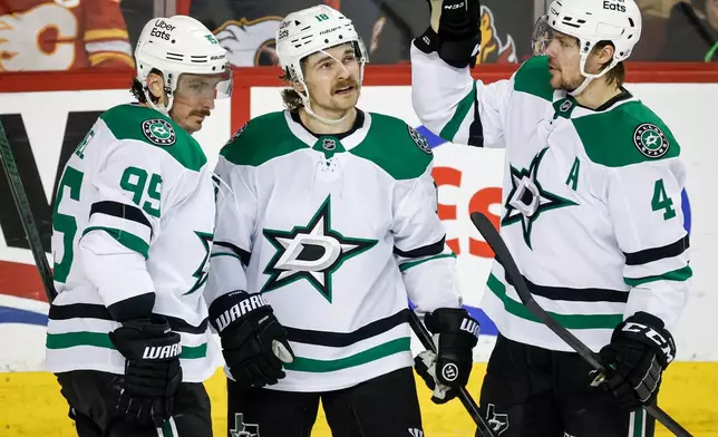 Dallas Stars' Sam Steel, center, celebrates his goal with teammates Matt Duchene, left, and Miro Heiskanen during the second period of an NHL hockey game against the Calgary Flames in Calgary, Alberta on Tuesday, March 3, 2026. (Jeff McIntosh/The Canadian Press via AP)