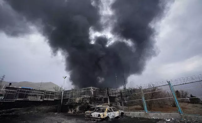 FILE - A thick plume of smoke rises from an oil storage facility hit by a U.S.-Israeli strike in Tehran, Iran, March 8, 2026. (AP Photo/Vahid Salemi, file)