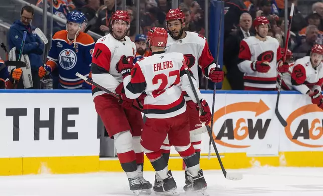 Carolina Hurricanes' Jordan Staal (11), Nikolaj Ehlers (27) and K'Andre Miller (19) celebrate a goal against the Edmonton Oilers during the third period of an NHL game, in Edmonton on Friday, March 6, 2026. (Jason Franson/The Canadian Press via AP)