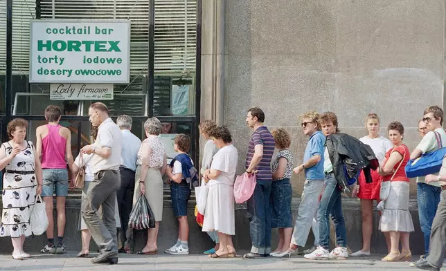 FILE - Customers queue outside a bakery in Warsaw, Poland, Aug. 23, 1989. (AP Photo/David Caulkin, File)