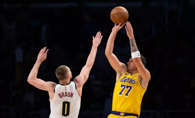 Los Angeles Lakers guard Luka Doncic, right, shoots as Denver Nuggets guard Christian Braun defends during the first half of an NBA basketball game in Los Angeles, Saturday, March 14, 2026. (AP Photo/Kyusung Gong)