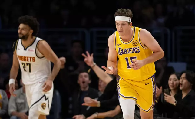 Los Angeles Lakers guard Austin Reaves, right, gestures after scoring a basket during the first half of an NBA basketball game against the Denver Nuggets in Los Angeles, Saturday, March 14, 2026. (AP Photo/Kyusung Gong)