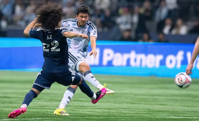 San Jose Earthquakes' Beau Leroux kicks the ball as Vancouver Whitecaps' Aziel Jackson (22) defends during the first half of an MLS soccer game in Vancouver, Saturday, March 21, 2026. (Ethan Cairns/The Canadian Press via AP)