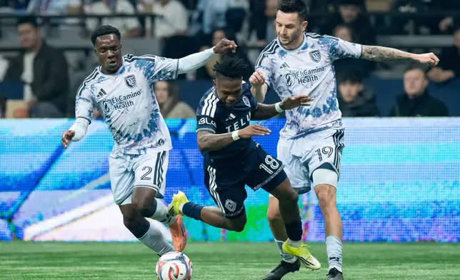 San Jose Earthquakes' Jamar Ricketts (2) and Preston Judd (19) trip Vancouver Whitecaps' Edier Ocampo (18) during the first half of an MLS soccer match in Vancouver, on Saturday, March 21, 2026. (Ethan Cairns/The Canadian Press via AP)