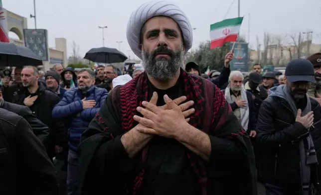 A cleric beats his chest as he mourns during the funeral procession of Iran's intelligence minister Esmail Khatib and, according to Iranian officials, his wife and daughter, in Tehran, Iran, Friday, March 20, 2026. (AP Photo/Vahid Salemi)