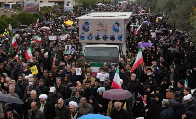 Iranians follow a truck carrying the coffins of Iran's intelligence minister Esmail Khatib and, according to Iranian officials, his wife and daughter, during a funeral procession in Tehran, Iran, Friday, March 20, 2026. (AP Photo/Vahid Salemi)