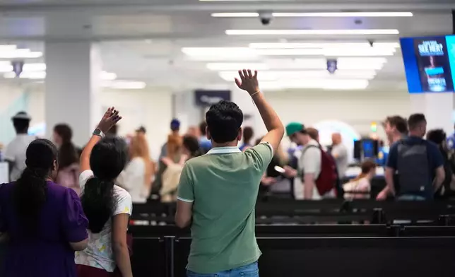 People wave goodbye to departing passengers at a TSA security screening checkpoint at the Jacksonville International Airport in Jacksonville, Fla., Monday, March 16, 2026. (AP Photo/Gerald Herbert)