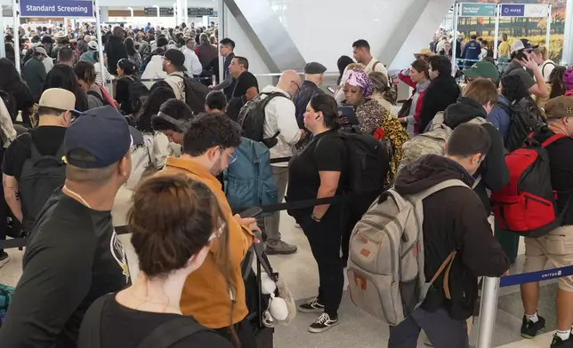 Airline passengers wait in long lines to get through the TSA security screening at George Bush Intercontinental Airport in Houston on Wednesday, March 18, 2026. (AP Photo/Lekan Oyekanmi)