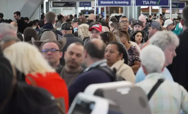 Airline passengers wait in long lines to get through the TSA security screening at George Bush Intercontinental Airport in Houston on Wednesday, March 18, 2026. (AP Photo/Lekan Oyekanmi)