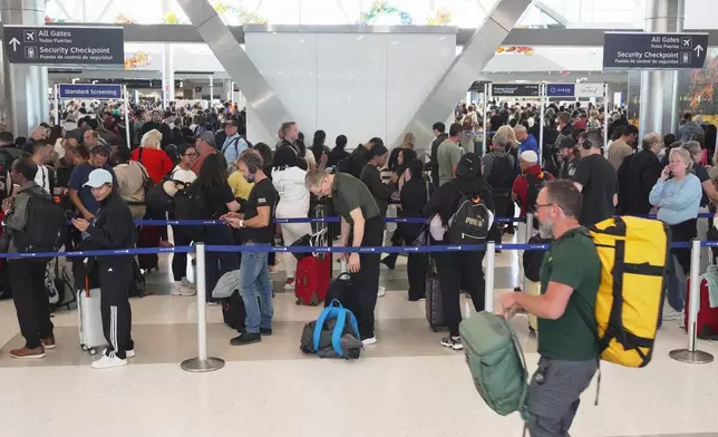 Airline passengers wait in long lines to get through the TSA security screening at George Bush Intercontinental Airport in Houston on Wednesday, March 18, 2026. (AP Photo/Lekan Oyekanmi)