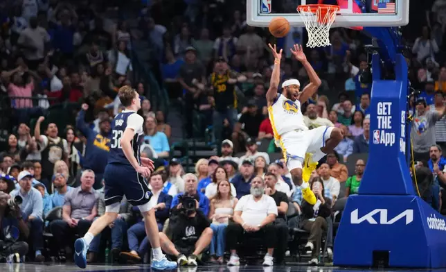 Golden State Warriors guard Moses Moody, right, reacts while suffering an injury as Dallas Mavericks forward Cooper Flagg (32) looks on during overtime of an NBA basketball game Monday, March 23, 2026, in Dallas. (AP Photo/Julio Cortez)
