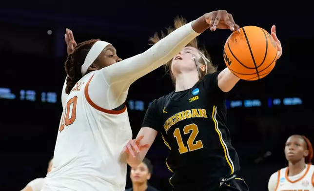 Texas center Kyla Oldacre (00) blocks a Michigan guard Syla Swords (12) shot during the second half in the Elite Eight of the NCAA college basketball tournament, Monday, March 30, 2026, in Fort Worth, Texas. (AP Photo/Tony Gutierrez)