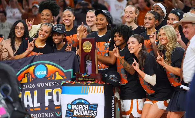 Texas players pose after beating Michigan in the Elite Eight of the NCAA college basketball tournament, Monday, March 30, 2026, in Fort Worth, Texas. (AP Photo/LM Otero)
