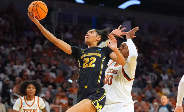 Michigan forward Kendall Dudley (22) drives on Texas center Kyla Oldacre (00) during the first half in the Elite Eight of the NCAA college basketball tournament, Monday, March 30, 2026, in Fort Worth, Texas. (AP Photo/LM Otero)