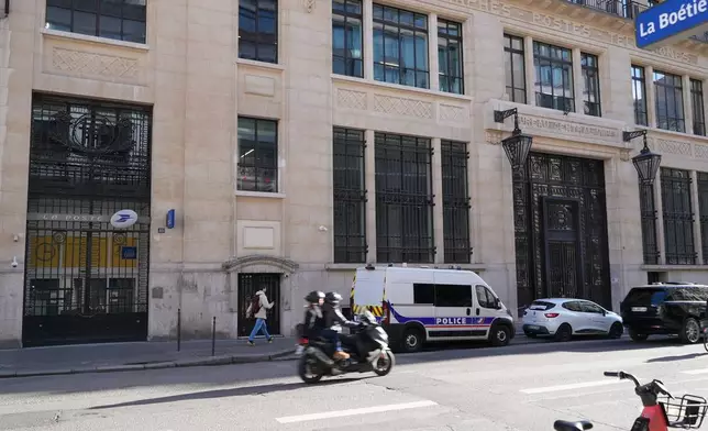 Police stand outside the Bank of America building in Paris, Saturday, March 28, 2026. (AP Photo/Nicolas Garriga)