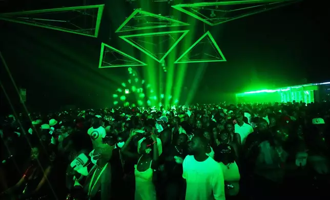 People dance in an auditorium to house music during a rave known as Group Therapy in Lekki, an upscale part of Lagos, Nigeria, Saturday, Feb. 28, 2026. (AP Photo/Sunday Alamba)